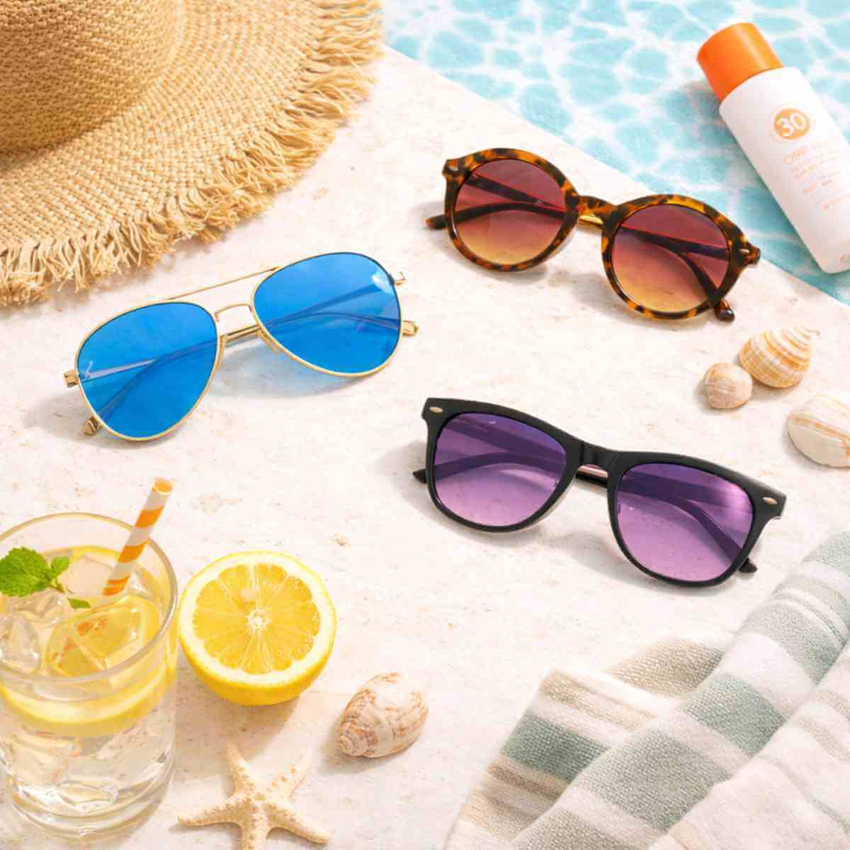 petite sunglasses for small faces arranged in a summer poolside flat lay featuring aviator, round tortoise, and black petite sunglasses with beach hat, sunscreen, lemon water, and pool backdrop designed for small head fit