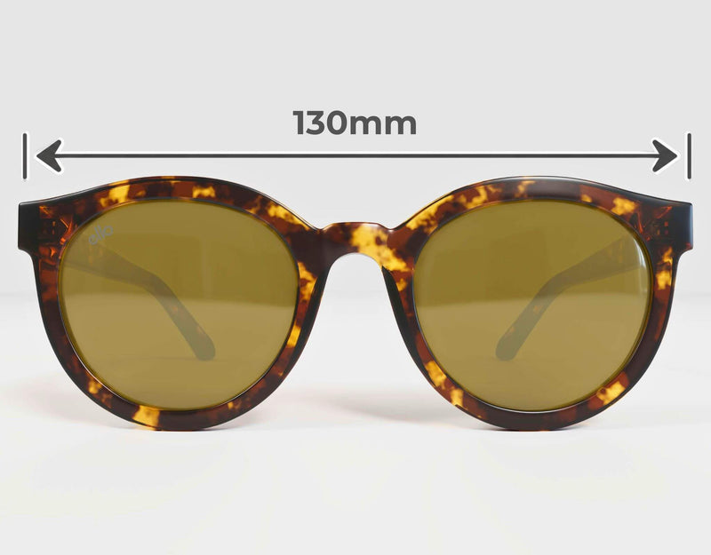 Front-facing view of ello Bar Harbor round tortoise sunglasses with brown-tinted lenses and measurement arrows showing the 130 mm overall frame width for petite faces.