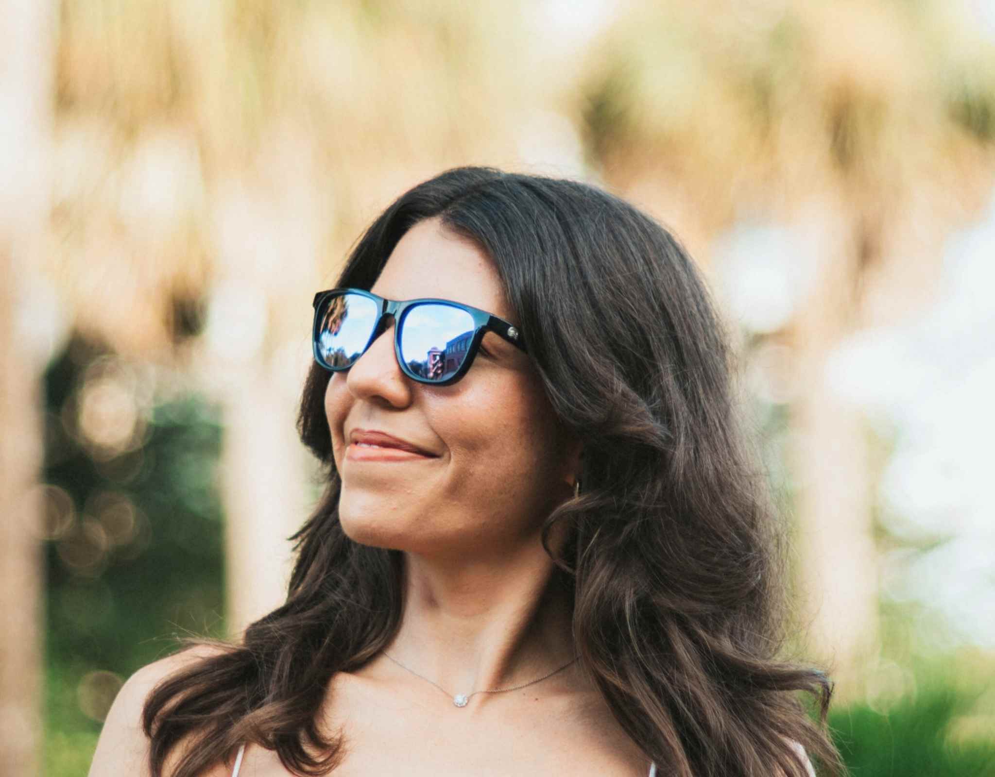 Woman wearing black purple mirrored sunglasses for petite features and small heads outdoors