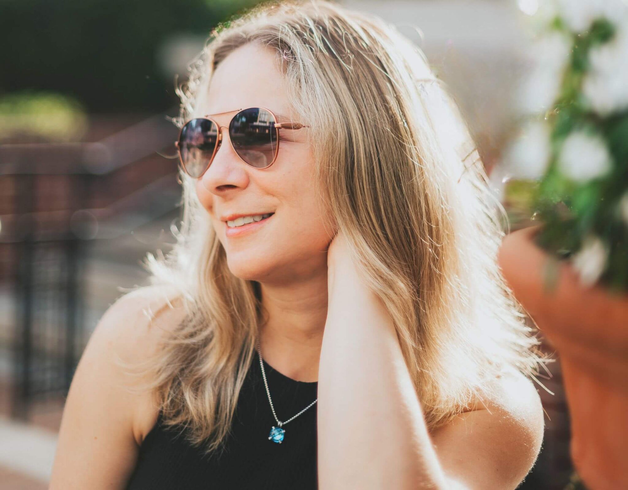 Woman wearing gold lavender Bali aviator small face sunglasses outdoors on a sunny day.