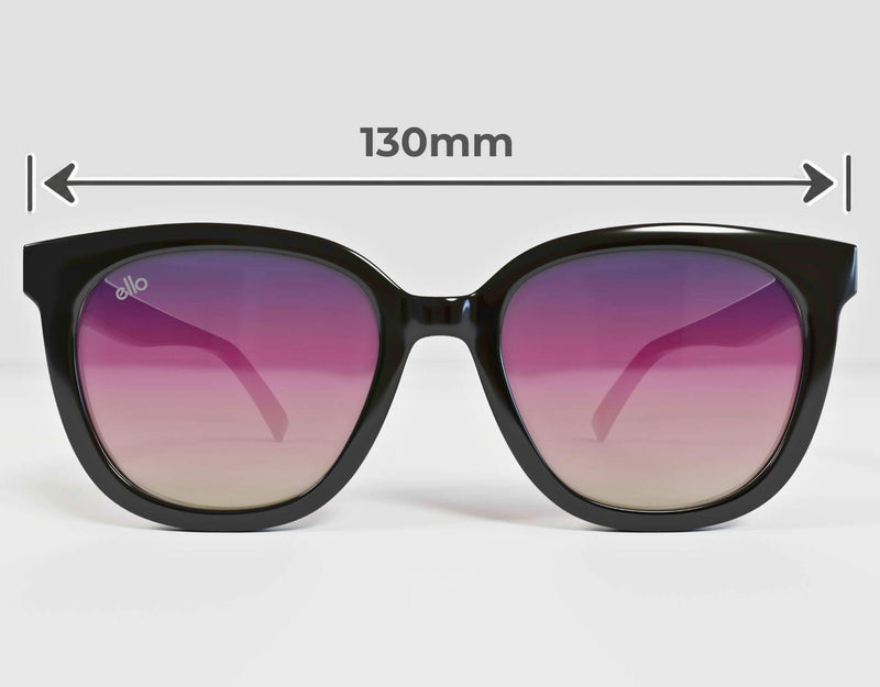 Front-facing view of ello Pebble Beach black butterfly sunglasses with purple gradient lenses and measurement arrows showing the 130 mm overall frame width for petite faces.