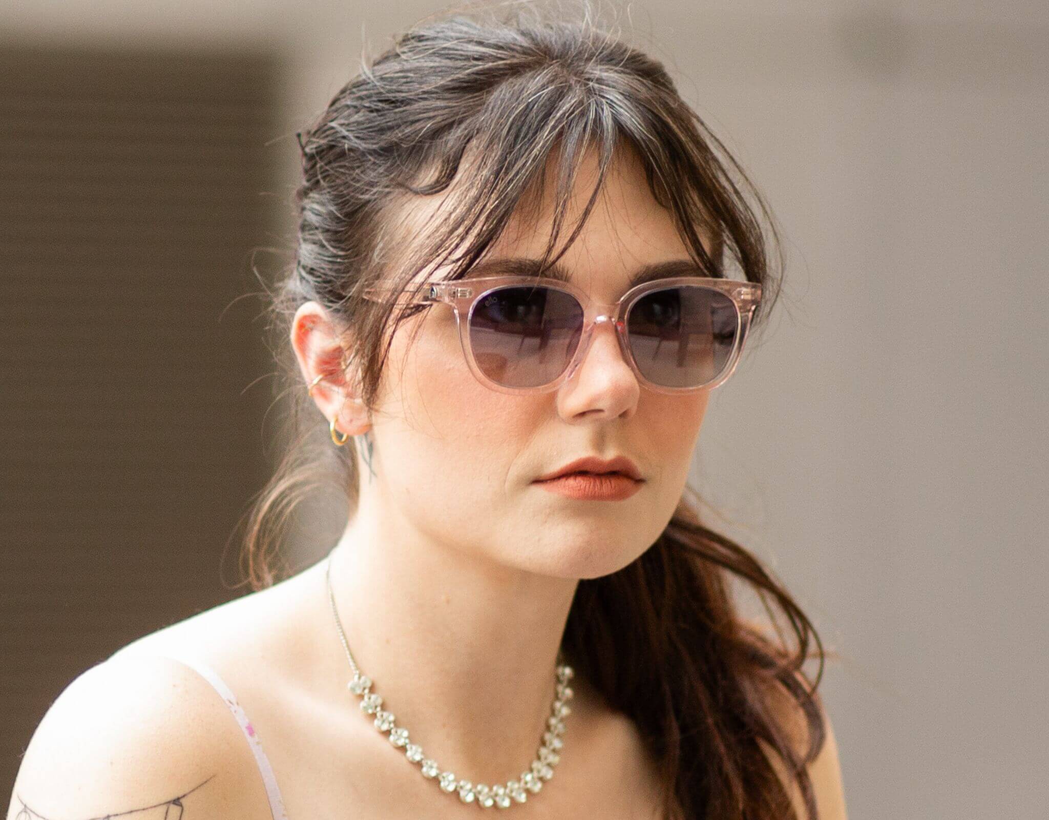 Woman wearing pink plum Pebble Beach sunglasses, designed for little faces on sunny day.