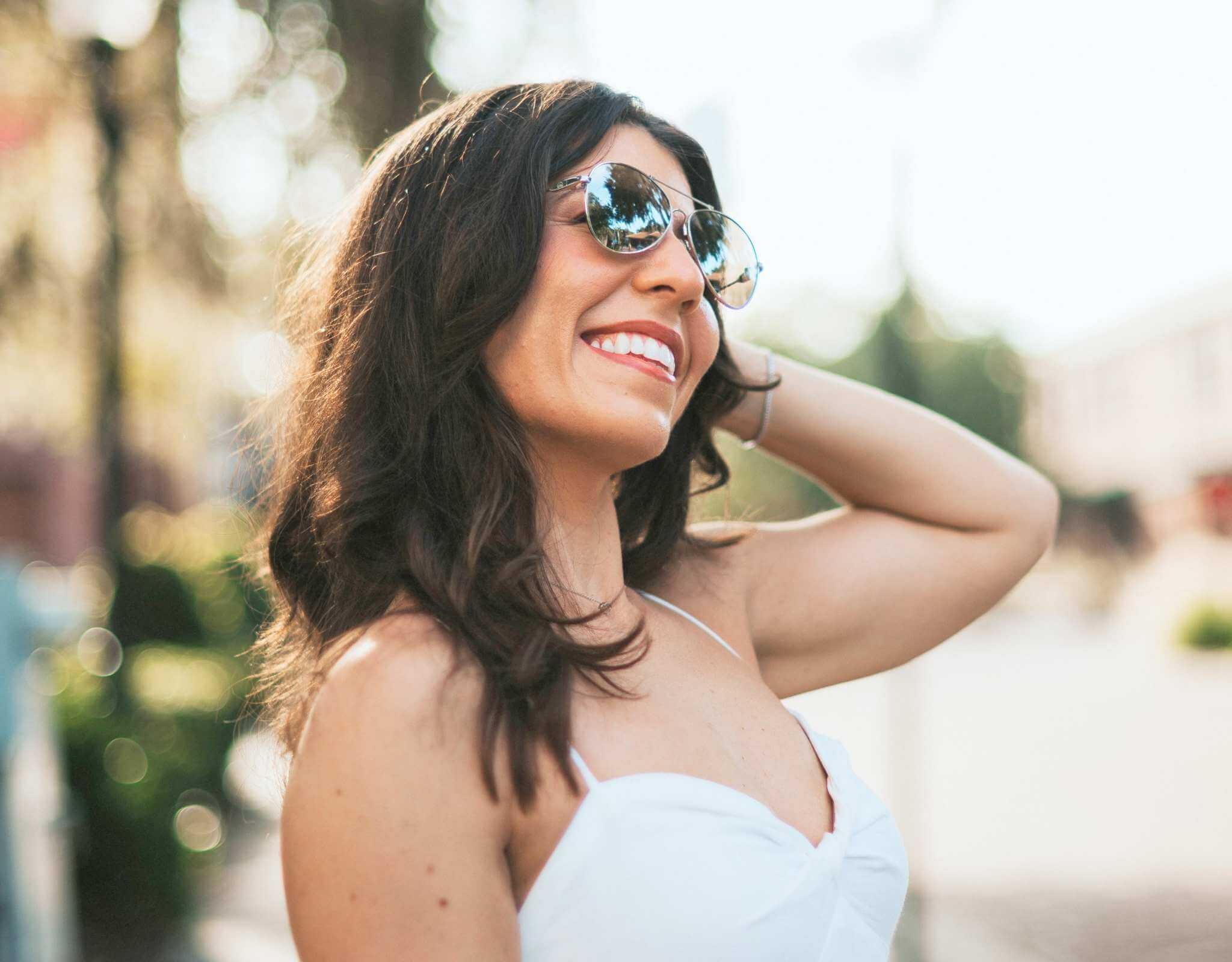 Stylish woman wearing silver grey Bali aviator small face sunglasses on a sunny day.