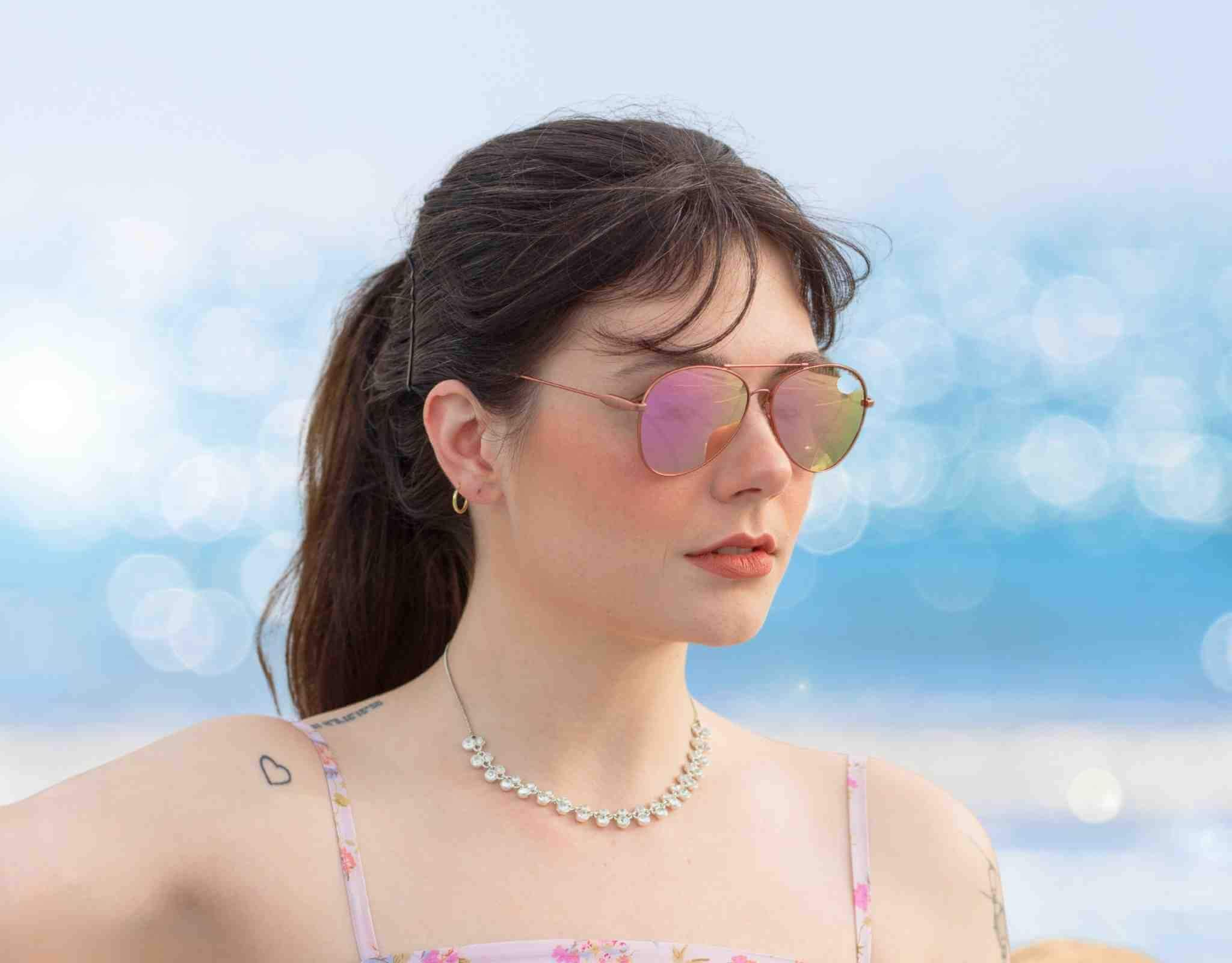Woman wearing Bali aviator sunglasses for petite faces by the ocean, lightweight metal frame designed for small head sizes and all-day comfort